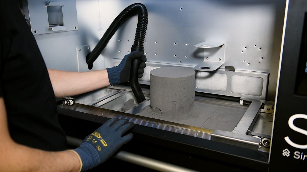  Ergonomics: The de-powdering process at the Material Handling Station (MHS) takes place on a comfortable level. The powder material that was not sintered gets vacuumed up and sieved for reuse. [Image credit: Sintratec AG] 